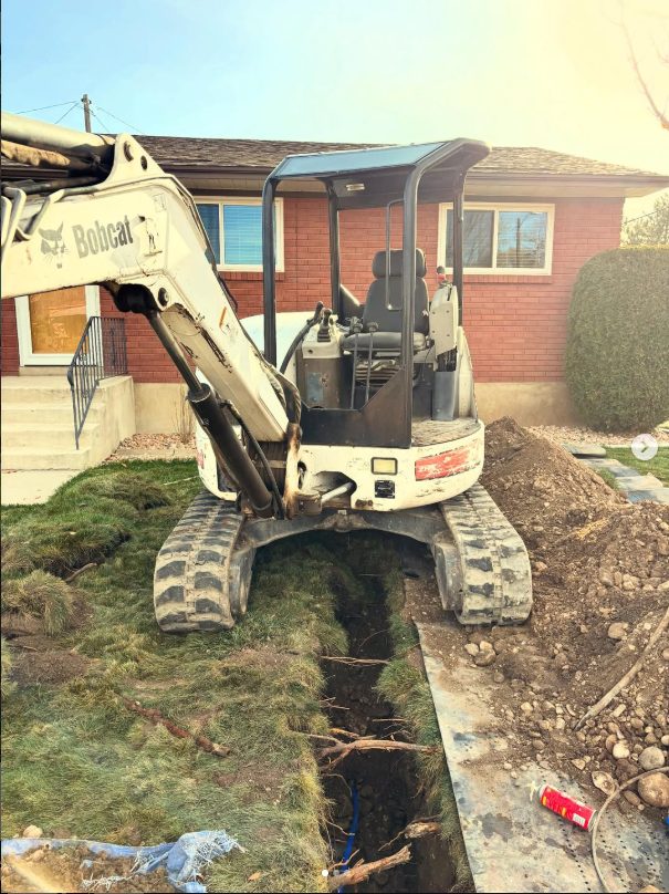 Mini excavator digging a water lateral trench in a front yard
