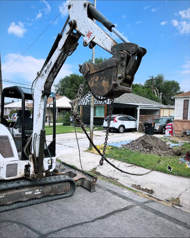 Excavator preparing to lower a water lateral hookup